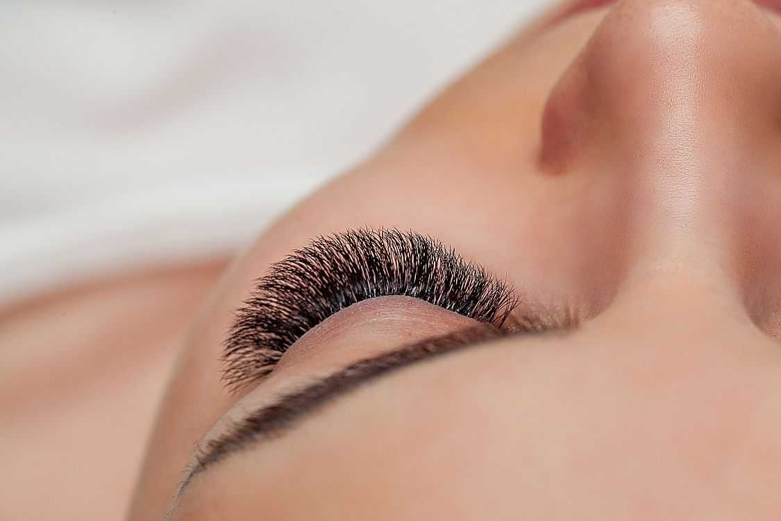 Close-up of a person's eye with long, full eyelashes.